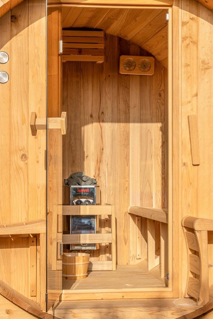 Houten sauna bij Casa Libertat met kachel en zitting voor ontspannende wellnessmomenten.