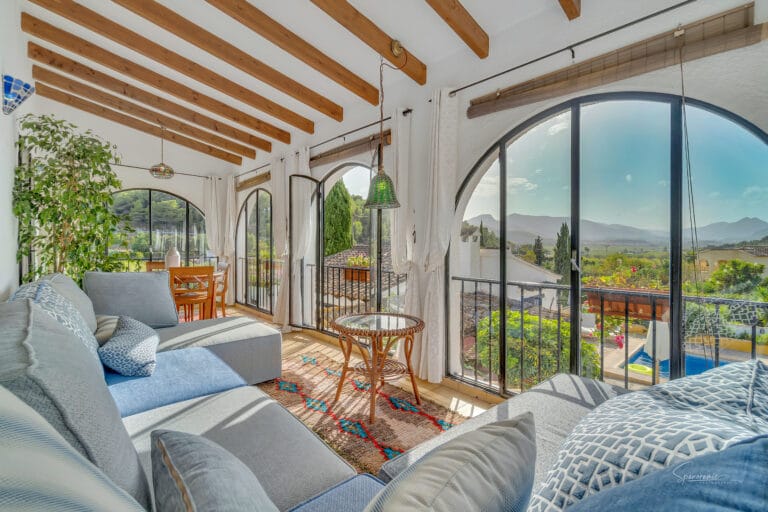 Comfortabele lounge hoek met grote ramen en uitzicht op het landschap bij Casa Llibertat.