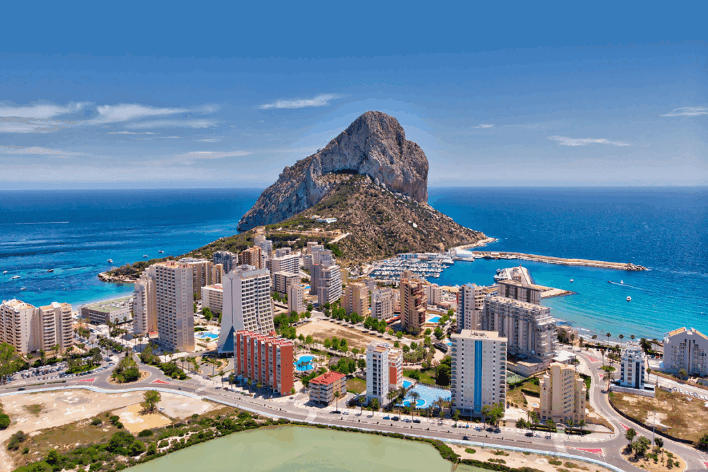 Vista aérea del parque natural del Penyal d'Ifac en Calpe con el mar Mediterráneo turquesa, ciudad costera y edificios residenciales en la provincia de Alicante, Costa Blanca.